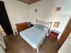 een slaapkamer met een bed, een nachtkastje en een lamp bij apartamento acogedor con piscina y chimenea in Nuevo Baztán