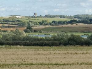 uma vista para um campo com uma torre de água à distância em Homeaway em Wellingborough