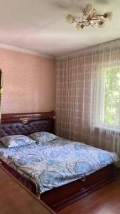 a bedroom with a bed and a window at Room in the house, with mountain views and squirrels in the yard in Almaty