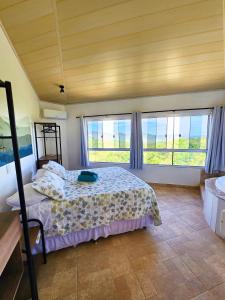 1 dormitorio con 1 cama y 2 ventanas en Bangalôs Canto da Coruja en Sao Jorge