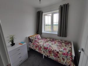 um pequeno quarto com uma cama e uma janela em Homeaway em Wellingborough