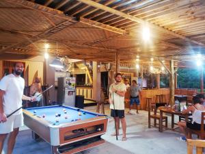 a group of people standing around a pool table at Raffiel Nias in Lagudri