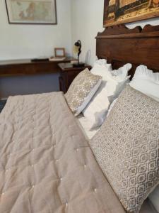 a bed with a wooden headboard and pillows on it at Bed&Breakfast Angela in Clusone