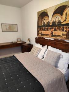 una camera da letto con un letto e un dipinto sul muro di Bed&Breakfast Angela a Clusone