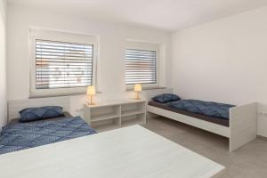 1 Schlafzimmer mit 2 Betten, einem Schreibtisch und 2 Fenstern in der Unterkunft RM Roma Studio in Celje