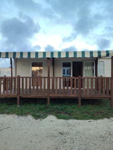 a house with a large wooden deck in front of it at Surya's Bungalow in Pataias
