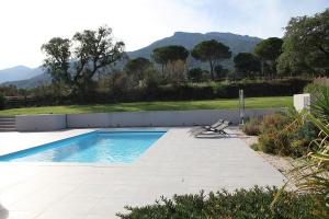 ein Pool mit einer Bank und Bergen im Hintergrund in der Unterkunft Modern 4 bedroom villa, air-conditioning, swimming pool, private gardens in Laroque-des-Albères