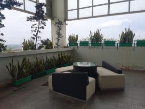 pokój z 2 krzesłami, stołem i roślinami w obiekcie Tamansari Mahogany Apartment By Sagita Residence Karawang w mieście Karawang