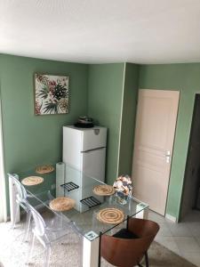 a dining room with a glass table with chairs and a refrigerator at la cave in Montoire-sur-le-Loir