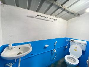 a bathroom with a toilet and a sink at Tapama Resort in Bakkhali