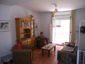 a woman sitting in a chair in a living room at La Alcandora in Granada
