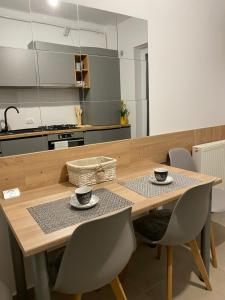 a kitchen with a wooden table with two cups on it at Deea H24 in Râşnov