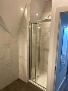 a shower with a glass door in a bathroom at The Glenbuck Hotel Anfield in Liverpool