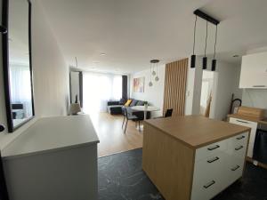 a kitchen and living room with a counter and a table at Apartament FANCY in Kielce +7 photos