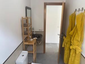 a bathroom with a sink and a toilet with yellow towels at SUNNY CARMELITO DELUXE in Mogán