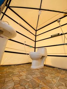 a bathroom with a toilet in a tent at Desert Stars Camp in Bidiyah