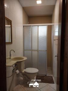 ein Bad mit einer Dusche, einem WC und einem Waschbecken in der Unterkunft Pomerânia Haus in Pomerode