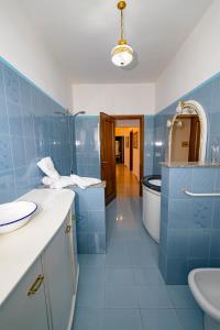 La salle de bains bleue est pourvue d'un lavabo et de toilettes. dans l'établissement Torlonia: Due matrimoniali e bagno, à Luco neʼ Marsi