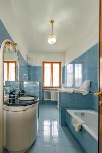 a blue bathroom with a tub and a sink at Torlonia: Due matrimoniali e bagno in Luco neʼ Marsi