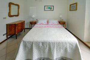 a bedroom with a white bed and two night stands at Torlonia: Due matrimoniali e bagno in Luco neʼ Marsi