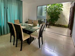 a dining room with a black table and chairs at El Encanto casa de descanso in Rivera