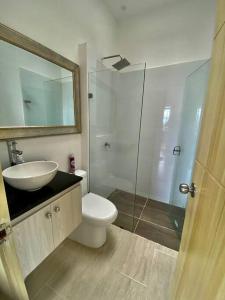 een badkamer met een toilet, een wastafel en een spiegel bij El Encanto casa de descanso in Rivera