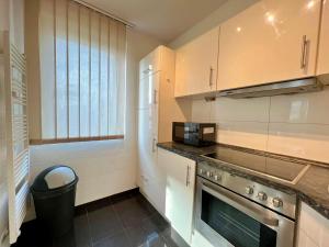 cocina con fogones horno superior junto a una ventana en Work&Stay Apartment - Kiel en Kiel