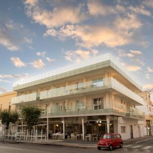 une voiture rouge garée devant un bâtiment dans l'établissement POPULA - The Lifestyle Hotel, à Gallipoli