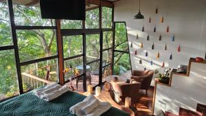 um quarto com uma cama e cadeiras e uma grande janela em Lindo LOFT VIP a 5 minutos de Cayala em Guatemala