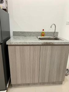 a kitchen counter with a sink and a refrigerator at Modena TownSquare in Minglanilla in Minglanilla