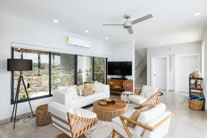 sala de estar con muebles blancos y ventilador de techo en Casa Cito, en Playa Hermosa