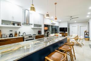 a kitchen with white cabinets and a blue counter top at Casa Cito in Playa Hermosa