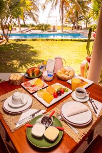 una mesa con platos de comida encima en Pousada Vila Sagui, en Maragogi