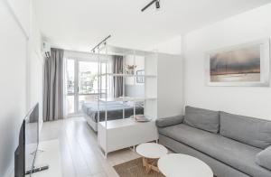 uma sala de estar com um sofá e uma cama em El Faro Apart em Buenos Aires