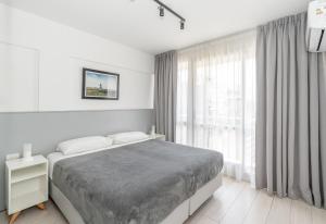 um quarto branco com uma cama e uma grande janela em El Faro Apart em Buenos Aires