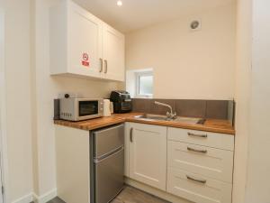a small kitchen with a sink and a microwave at Rabbits Warren in Lydney