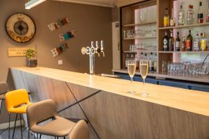 a bar with two glasses of wine on the counter at Hôtel Lac d'Orient in Mesnil-Saint-Père