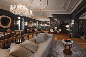 - un salon avec un canapé et un lustre dans l'établissement GA Palace Hotel & Spa, a XIXth-Century Villa, à Porto