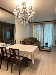 a living room with a table and a chandelier at OV Residence in Bangkok