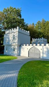 a white building with a gate in the grass at Basztogród in Sanok