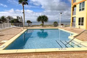 a swimming pool with the ocean in the background at Summerhouse 402 in Mexico Beach