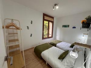 Un dormitorio con 2 camas y una escalera. en El Bressol de la Muntanya, en Ripoll