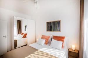 biała sypialnia z łóżkiem i lustrem w obiekcie Villa Beller New w mieście Ičići