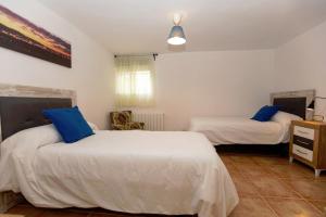 a bedroom with two beds with blue pillows at Casa Jurinea Alzar in Torres