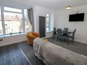 1 dormitorio con 1 cama y comedor con mesa en Flat 2 Englehurst Mews, en Buxton