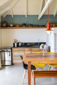 a kitchen with a wooden table and yellow chairs at Pé na areia, tranquilidade,conforto,2 quartos, ar-cond, Wi-Fi, pet-friendly, 7 pessoas, in Bombinhas