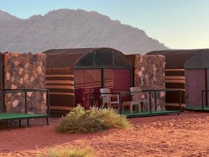 un edificio nel deserto con delle sedie dentro di Bedouin Lifestyle Camp a Wadi Rum