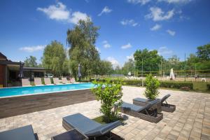 a pool with chaise lounge chairs and a swimming pool at Mohácsi Wellness Vendégház és Lovasklub in Mohács