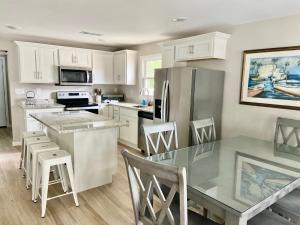 a kitchen with white cabinets and a table and chairs at ON Deck few Blocks Fr BEACH 6 BR/4Ba Newly Reno in Myrtle Beach