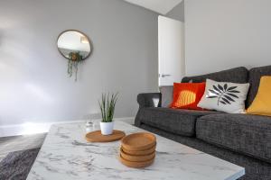 ein Wohnzimmer mit einem Sofa und einem Tisch in der Unterkunft Beautiful Ground Floor Apartment in Perth